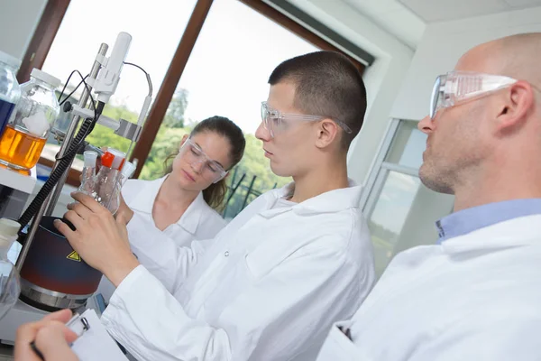Studenten die werken op experiment in hij laboratorium — Stockfoto