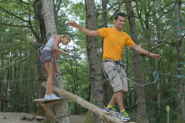 Pareja escalando cuerda en el parque de aventuras — Foto de Stock
