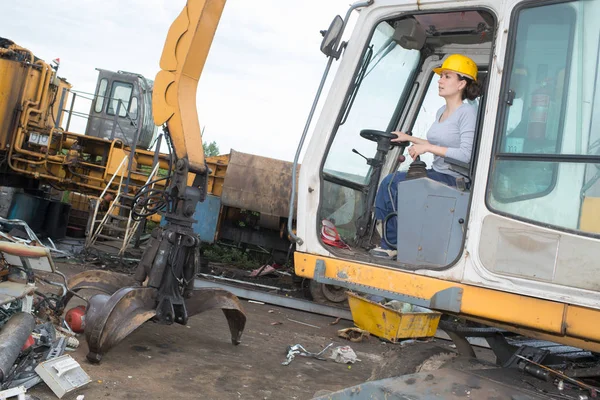 Kvinna styra grävare med grab fastsättning — Stockfoto