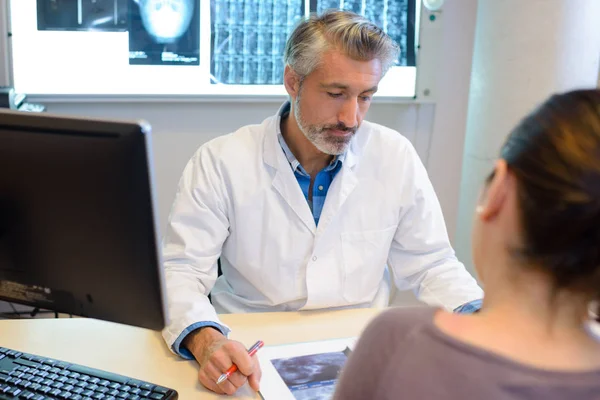 Medico con espressione seria che parla con paziente donna — Foto Stock