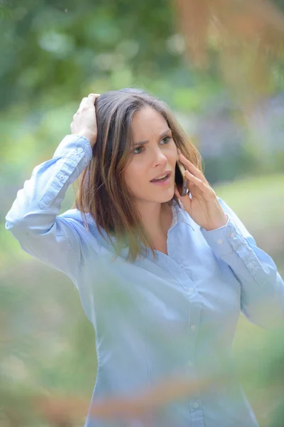 Dame im Freien am Telefon sieht beunruhigt aus — Stockfoto