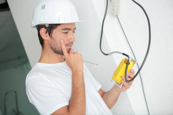 Jeune homme installant prise sur le mur à la maison — Photo