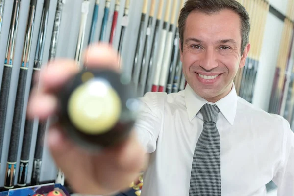 Jovem empresário bonito segurando bola de bilhar — Fotografia de Stock