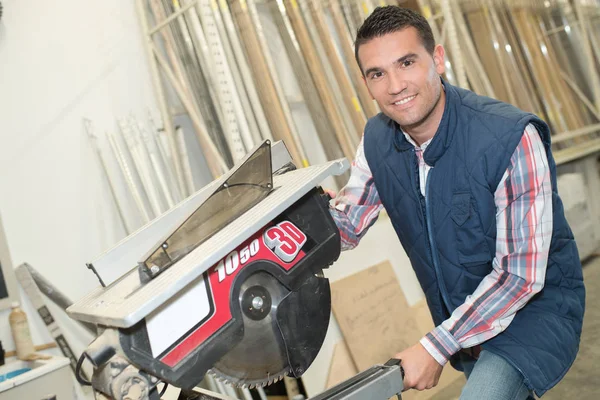 Homem trabalhando com uma serra circular grande corte dentro de casa — Fotografia de Stock