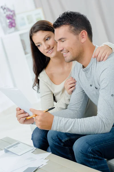 Pareja sonriente mirando papeleo —  Fotos de Stock