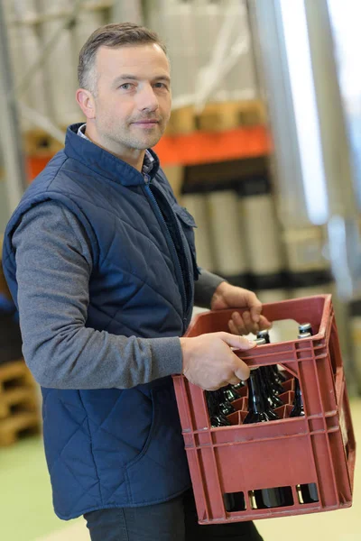 Fabricante carregando garrafas na cervejaria — Fotografia de Stock