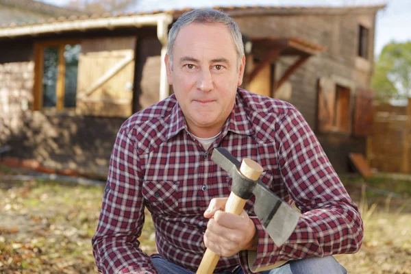 Man holding axe in garden — Stock Photo, Image