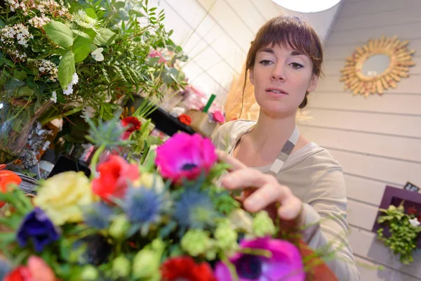 Blumenhändlerin nimmt eine Blume — Stockfoto