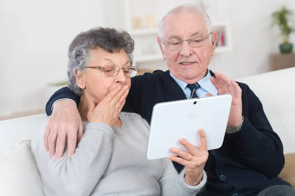 Couple d'âge mûr utilisant une tablette numérique dans leur appartement — Photo