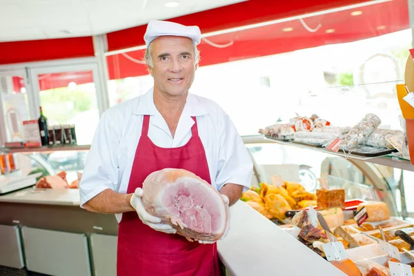 Carnicero sosteniendo un jamón — Foto de Stock