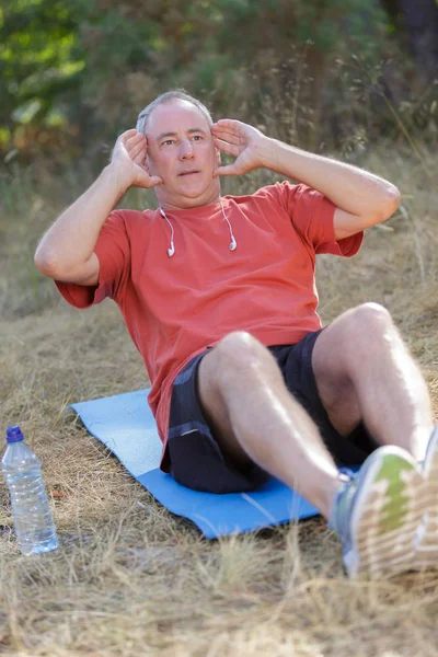 Viejo hombre ejercicio sentarse — Foto de Stock