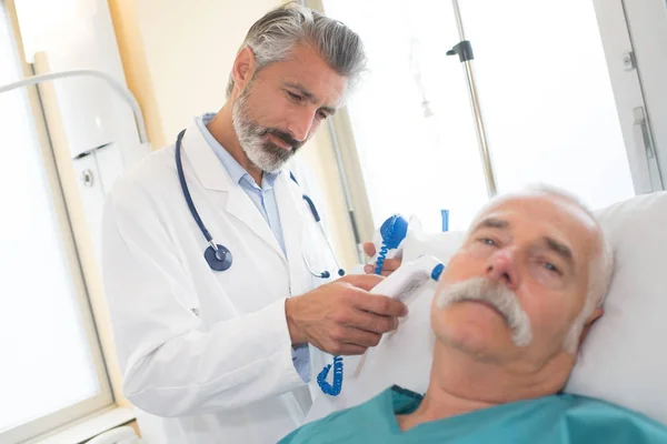 Läkaren undersöker en äldre patient — Stockfoto
