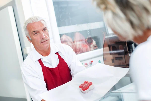 Metzger bedient einen Kunden — Stockfoto