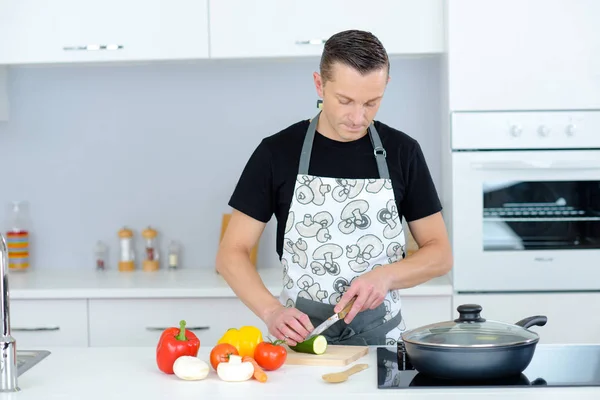 Mann hackt Gemüse in der Küche — Stockfoto