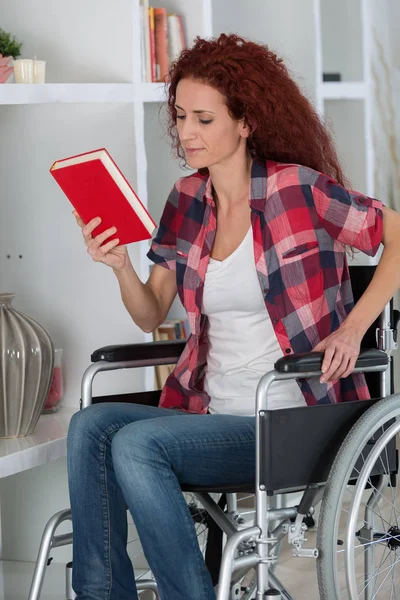 Behinderte Frau im Rollstuhl liest Buch — Stockfoto