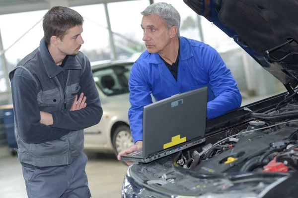 Estudante com instrutor reparar um carro durante a aprendizagem — Fotografia de Stock