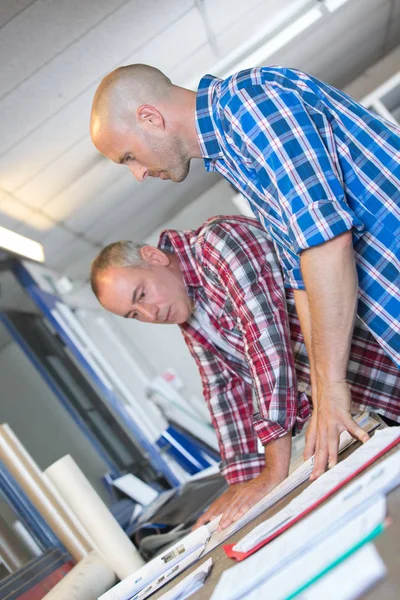 Двое мужчин-дизайнеров смотрят на планы — стоковое фото