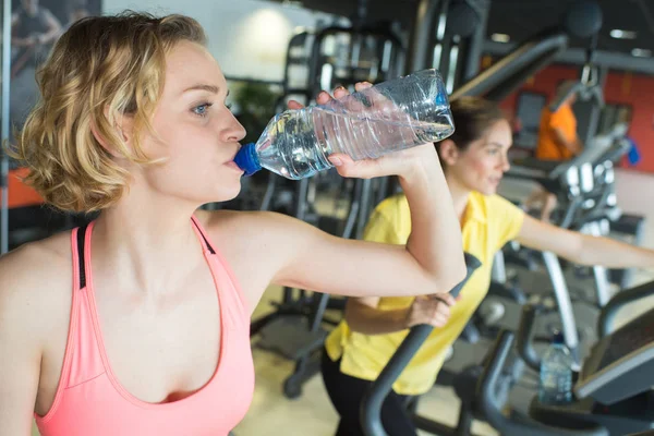 Donna muscolosa che beve acqua in crossfit — Foto Stock