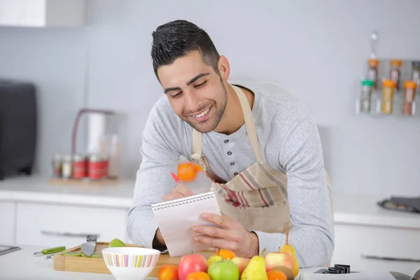 Cocinar y comprobar la comida en la receta — Foto de Stock