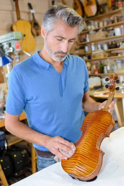 Homem em oficina polimento violino — Fotografia de Stock