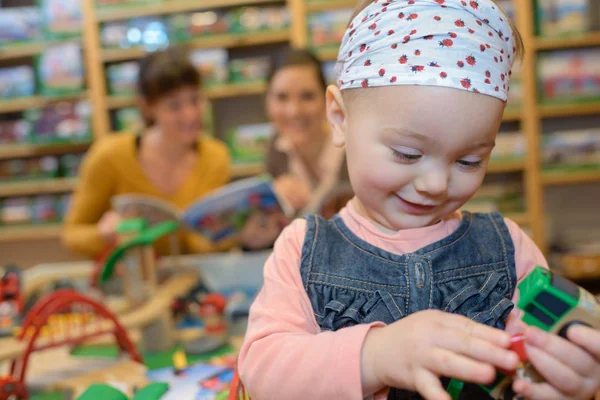 Gamin jouer pendant que maman parle à il vendeur — Photo