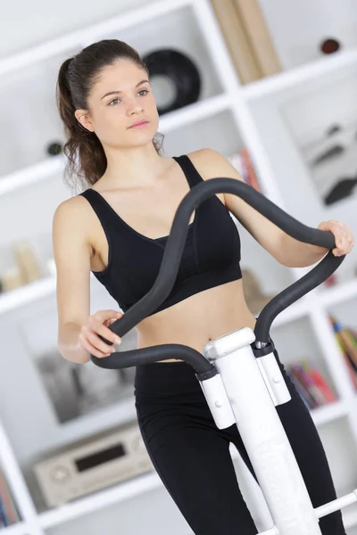 Jovem e atraente fitness exercício em uma máquina cardio — Fotografia de Stock