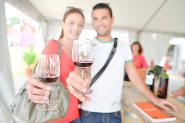 Pareja sosteniendo gafas de vino en brazos extendidos —  Fotos de Stock