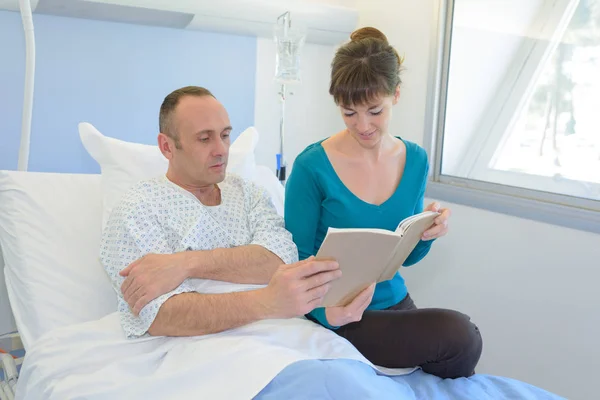 关心妻子的丈夫在医院读书 — 图库照片