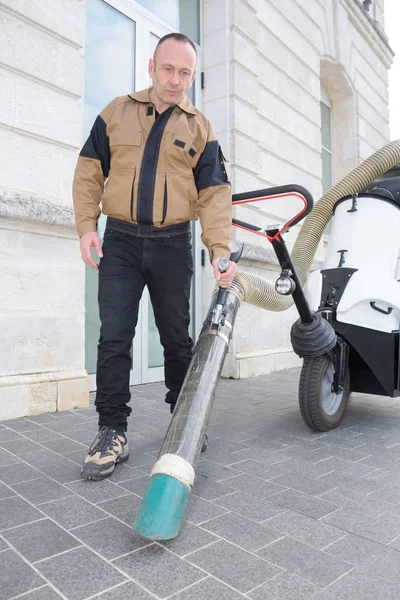 Självsäker manliga vaktmästare med dammsugare på gatan — Stockfoto