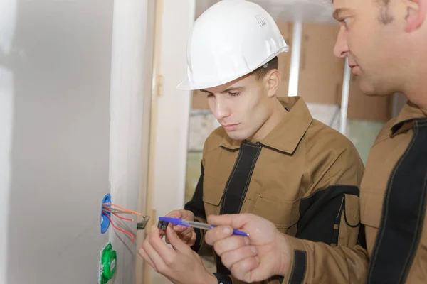 Mladí elektrikáři, elektroinstalace, zásuvky — Stock fotografie