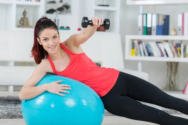 Young sportswoman doing exercises with ball and dumbbells — Stock Photo, Image