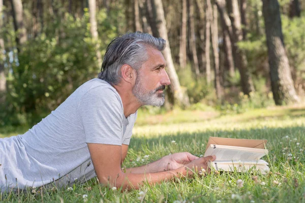 Hombre Acostado Hierba Leyendo Libro — Foto de Stock