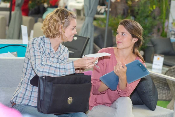 Vrouw met winkelbediende in meubilairopslag bespreken — Stockfoto