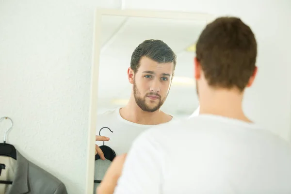 Genç Adam Çalışırken Gömlek Üzerinde Aynanın Önünde — Stok fotoğraf