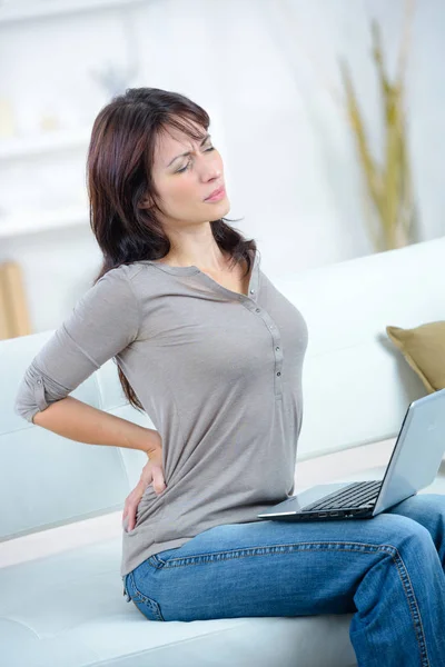 笔记本电脑伸展疼痛的妇女背部 — 图库照片