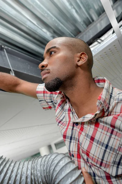 Uomo in tettoia con tubo di ventilazione — Foto Stock