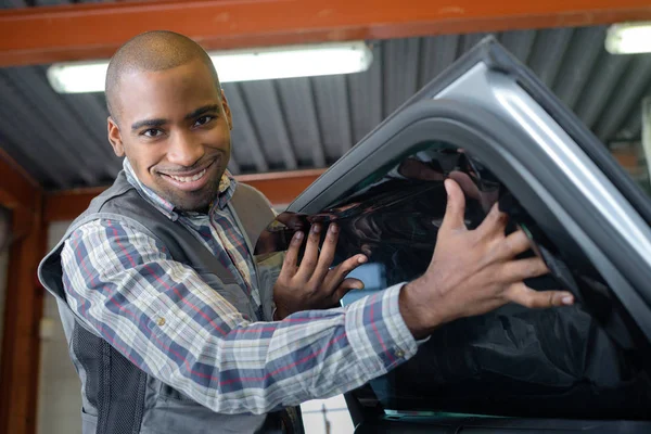 Sorridente Jovem Mecânico Masculino Inspecionando Carro Reparação Automóveis — Fotografia de Stock