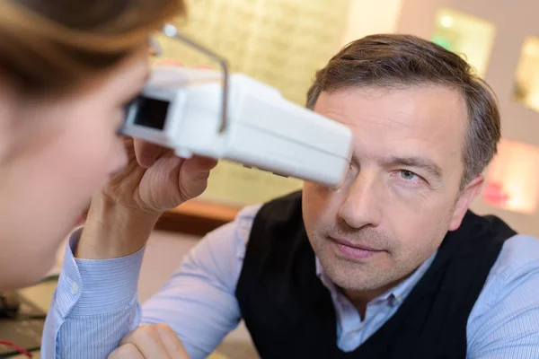 Vista lateral de un óptico haciendo pruebas visuales para el cliente — Foto de Stock