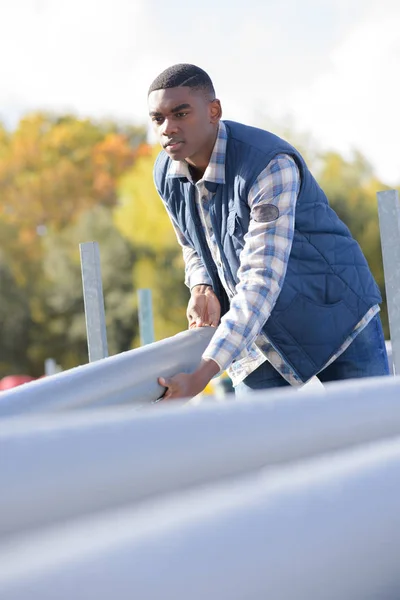 Arbeiter hält Abwasserrohre im Freien — Stockfoto