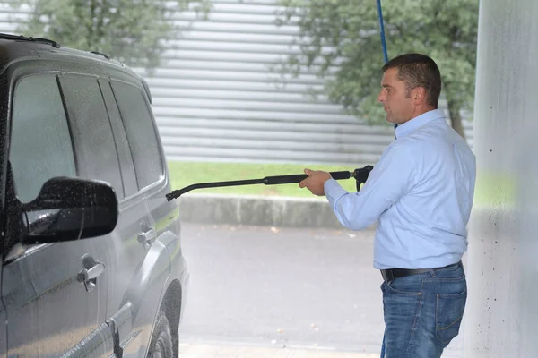 Homme nettoyage de voiture en utilisant de l'eau haute pression — Photo