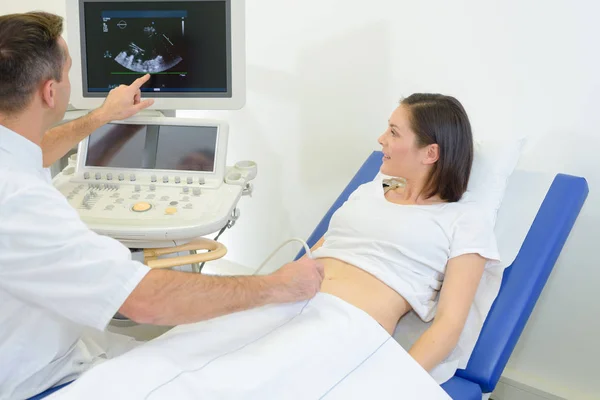 Médico aplicando gel na barriga da mulher no hospital — Fotografia de Stock