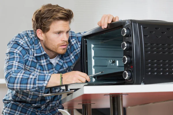 Joven Reparador Masculino Horno Fijación Cocina —  Fotos de Stock