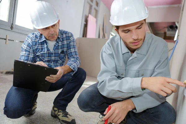 Aprendiz e mentor que trabalha no estaleiro de construção — Fotografia de Stock