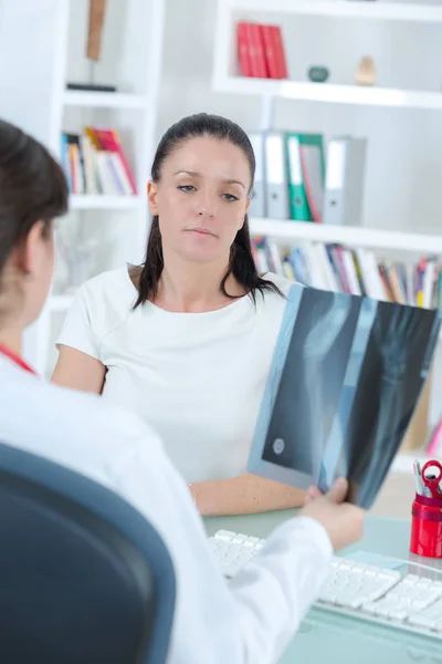 Ärztin und Patientin betrachten Röntgenbild — Stockfoto