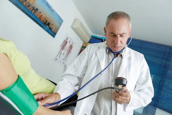 Enfermeira verificando a pressão arterial do paciente — Fotografia de Stock