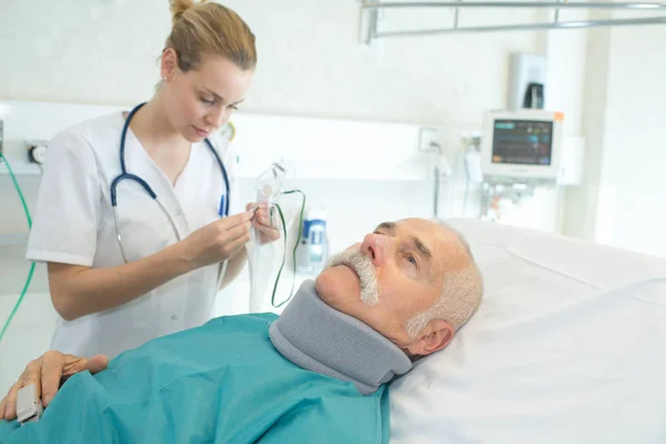 Krankenschwester pflegt Patientin mit Nackenstütze — Stockfoto