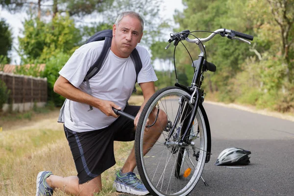 Portret Przystojny Mężczyzna Pompowania Opon Rowerowych Parku — Zdjęcie stockowe