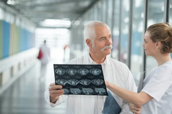 Старший Лікар Який Показує Пацієнтам Медсестри Рентген Лікарняному Коридорі — стокове фото