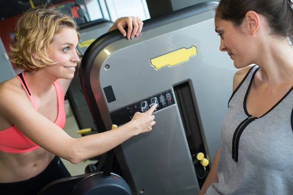 在健身房使用机器的妇女 — 图库照片