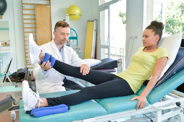 Erwachsener Männlicher Physiotherapeut Der Das Bein Einer Patientin Behandelt — Stockfoto